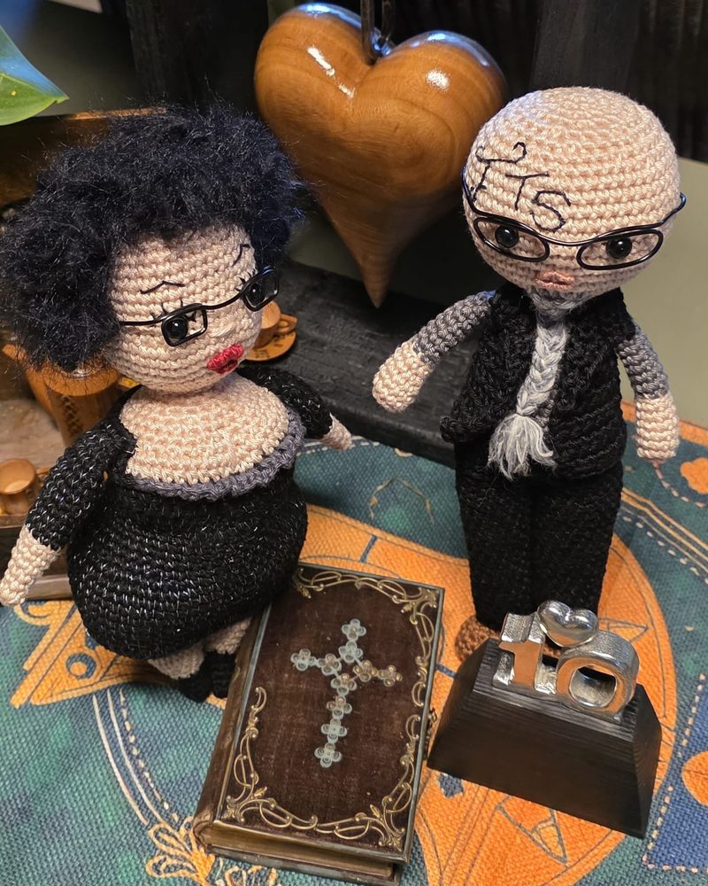 Crocheted dolls of Elly and Flipke beside an old bible
