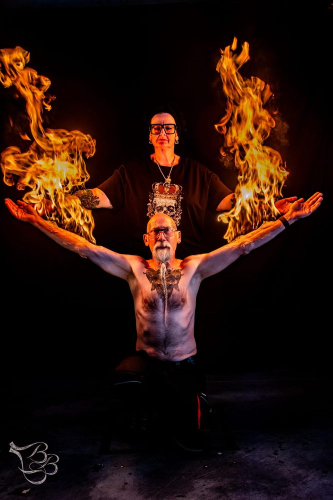 Elly and Flipke with flames rising from their outstretched arms