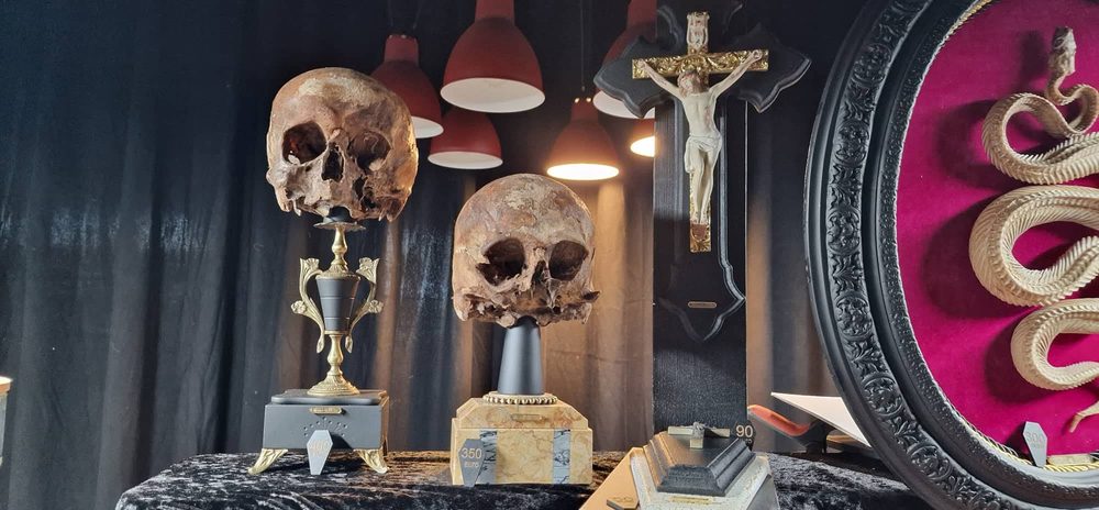 Market stall with two skulls on stands and a crucifix